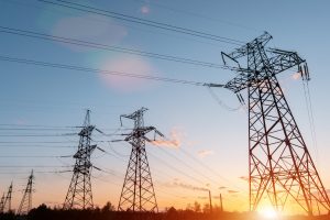 distribution electric substation with power lines and transformers, at sunset